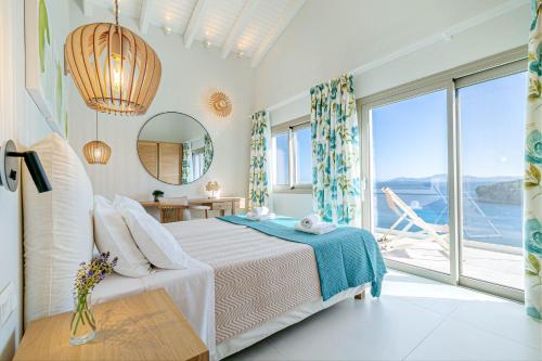 a bedroom with a bed and a large window at Kalami Beach - Villa Mara in Kalami