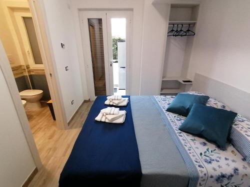 um quarto com uma cama azul com toalhas em Parco dei Gerani em Formia