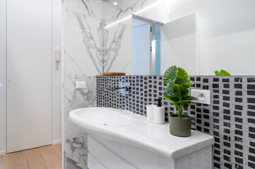 La salle de bains blanche est pourvue d'un lavabo et d'un miroir. dans l'établissement Nice Renting - BAVASTRO - Luxurious Loft - 2 BedRoom - AC - Balcony - Trendy Neighborhood, à Nice