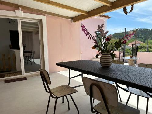 einen Tisch mit einer Blumenvase auf einer Terrasse in der Unterkunft Mãe Home Story in Caldas da Rainha