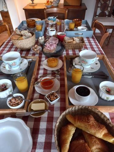 une table avec un petit-déjeuner composé de pain et de boissons dans l'établissement Chambre d'hôte Montlivault / Chambord, à Montlivault