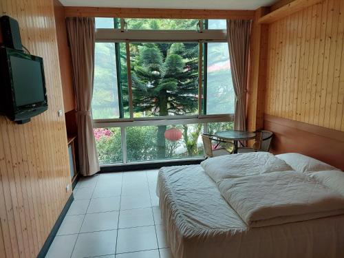 a bedroom with a bed and a large window at Very Happy Homestay in Pingxi