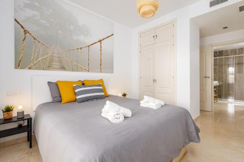 a bedroom with a large bed with towels on it at Nordik Apartments Village - Torrox "Tønsberg" in Torrox Costa