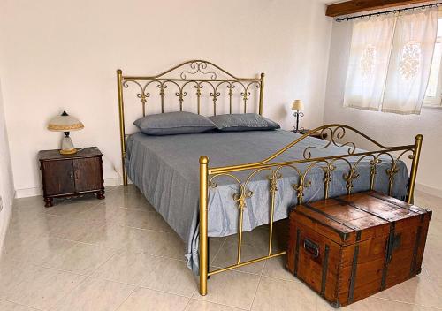 1 dormitorio con cama con marco de metal y mesa en Villa Finestra sul Castello, en Partinico