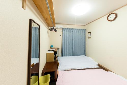Cette petite chambre comprend 2 lits et un miroir. dans l'établissement 多目的スタジオ月兎園 BBQや花火できます #Ok1, à Yoshioka