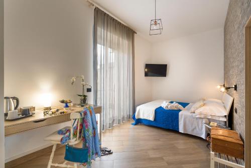 a bedroom with a bed and a desk and a sink at Il Tempio di Athena - Cultura e Relax a Siracusa in Siracusa
