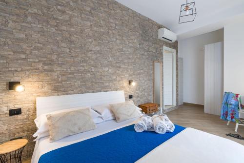 a bedroom with a bed and a brick wall at Il Tempio di Athena - Cultura e Relax a Siracusa in Siracusa