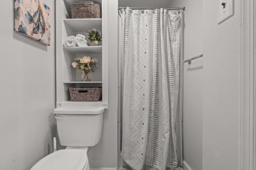 łazienka z toaletą i zasłoną prysznicową w obiekcie East Passyunk Trendy Apartment w Filadelfii