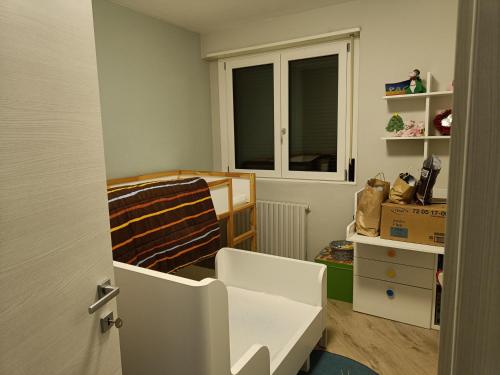 een kleine kamer met een bed en een raam bij Appartamento Tranquillo con Giardino in Morbegno