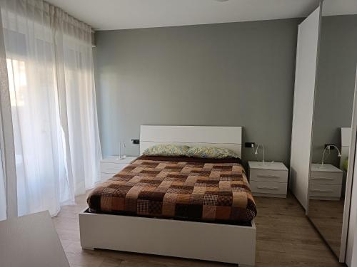 een slaapkamer met een bed en een groot raam bij Appartamento Tranquillo con Giardino in Morbegno