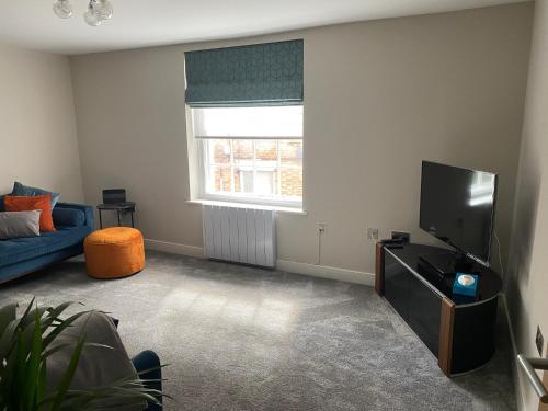 a living room with a blue couch and a tv at RECENTLY RENOVATED property in the heart of Southwell in Southwell