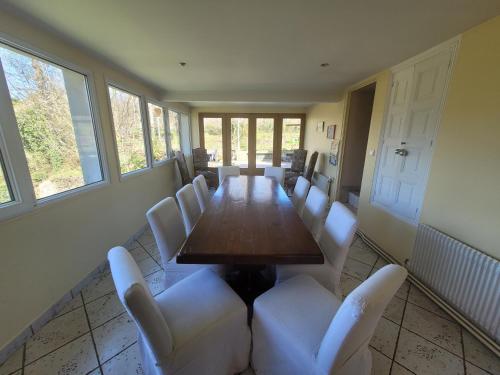 a conference room with a long table and white chairs at Le moulin de Meslon in Coust