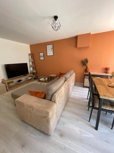 uma sala de estar com um sofá e uma mesa em Appartement Centrale Confort em Montalieu-Vercieu