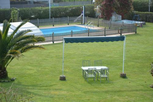 a table and chairs in a yard next to a pool at Hotel Finca La Mansión in Llanes