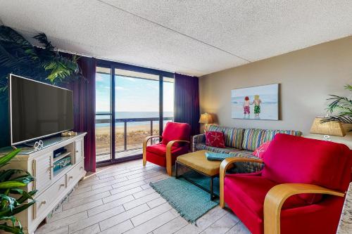 ein Wohnzimmer mit einem Sofa, Stühlen und einem TV in der Unterkunft Golden Sands IV in Ocean City
