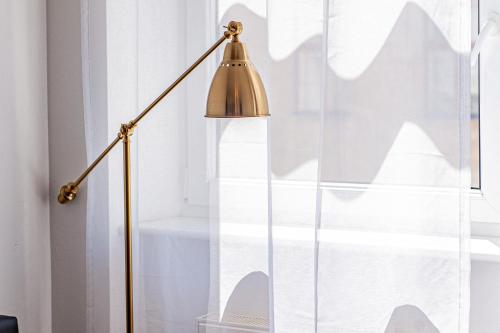 a brass floor lamp next to a window at My city apartment - Vienna CityRoom in Vienna