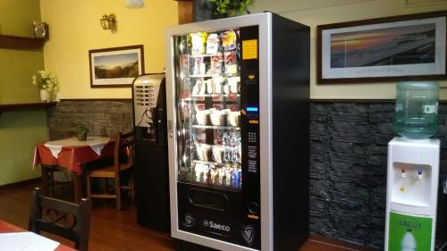una máquina expendedora de refrescos en un restaurante con mesa en Hotel Rivera, en Colonia del Sacramento