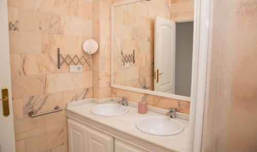 a bathroom with two sinks and a mirror at Apartamentos Casa Tuli C, ALJARAQUE in Aljaraque