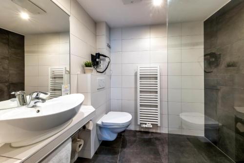 a bathroom with a sink and a toilet and a shower at AKZENT Hotel Restaurant Roter Ochse Rhens bei Koblenz in Rhens