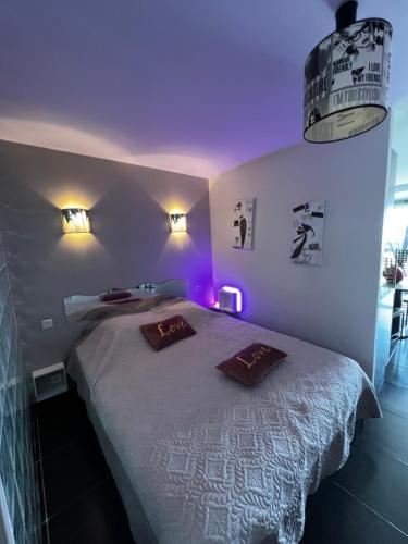 une chambre avec un grand lit avec des lumières violettes dans l'établissement Cap d’Agde, Village naturiste, port nature 5, coursive, au Cap d'Agde