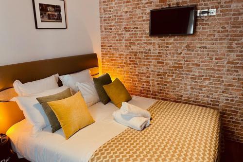Cette chambre comprend un lit avec des oreillers et un mur en briques. dans l'établissement HUDSON HIGHLANDS Annecy Rent Lodge, à Annecy