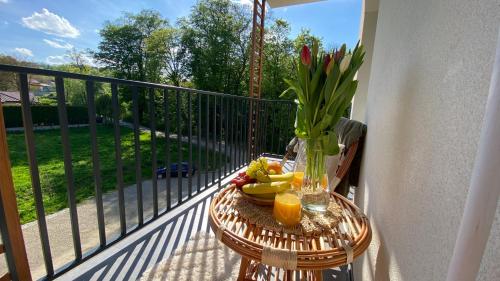 stół z owocami i wazon kwiatów na balkonie w obiekcie Apartament Park w mieście Przemyśl
