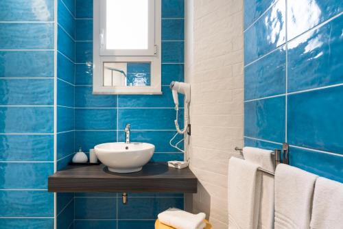 a blue tiled bathroom with a sink and a mirror at Il Tempio di Athena - Cultura e Relax a Siracusa in Siracusa