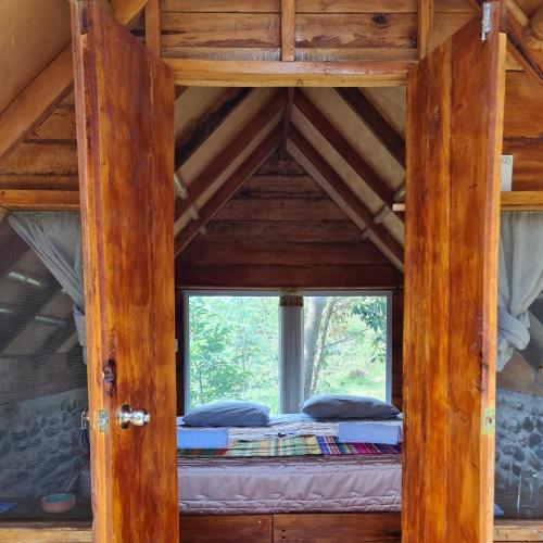 a bed in a room with a window at Cacao Glamping in Cotundo