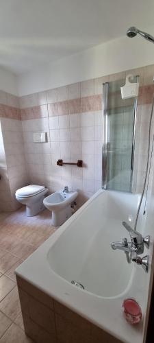a bathroom with a tub and a toilet and a sink at La Casetta di Sornico in Lierna