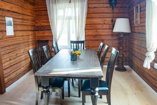 a dining room with a table and chairs and a lamp at Peramaa Puhkekeskus in Meeksi