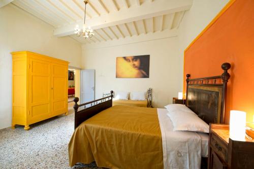a bedroom with a large bed and a yellow cabinet at Casa vacanze Fatucchi in Foiano della Chiana