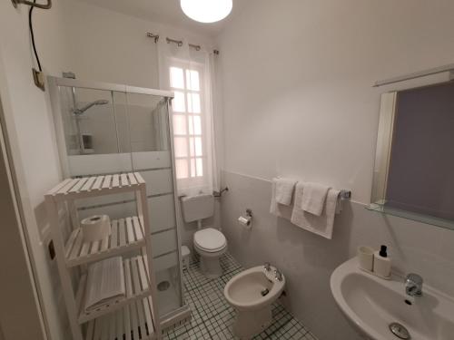 La salle de bains blanche est pourvue de toilettes et d'un lavabo. dans l'établissement Casavacanze nel Blu scirocco, à Isola delle Femmine