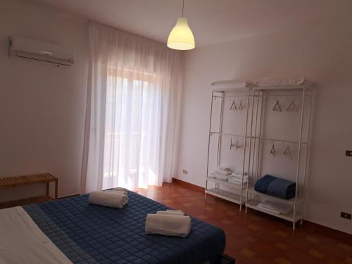 a bedroom with a bed and a large window at Casavacanze nel Blu scirocco in Isola delle Femmine