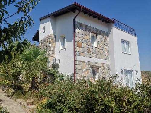 a white house with a stone facade at Iasos villa in Milas