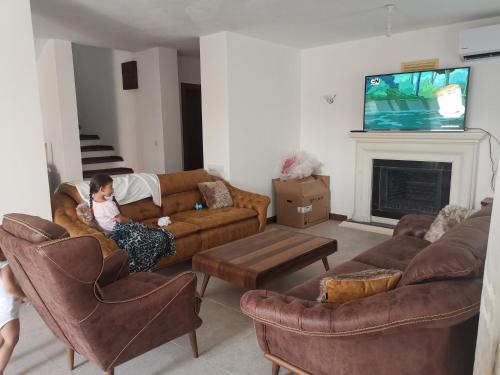 a woman sitting on a couch in a living room at Iasos villa in Milas