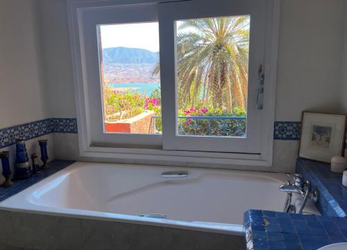 a large bath tub in a bathroom with a window at Les Cactus in Bine el Ouidane