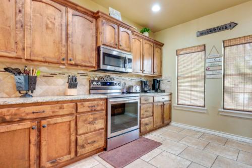 a kitchen with wooden cabinets and a stove top oven at Lodge at Rocky Creek with Private Hot Tub and Yard! in Canyon Lake