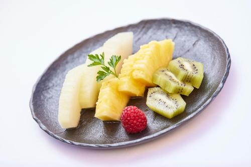 a black plate with fruit on a white background at MLL Blue Bay in Palma de Mallorca