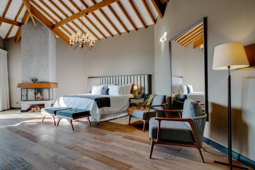 a bedroom with a bed and a table and chairs at Mirante da Colyna Hotel & SPA in Monte Verde