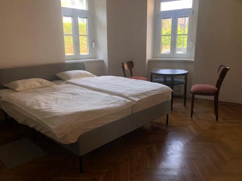 een slaapkamer met een bed en twee stoelen en twee ramen bij Zaži Orient Express Istanbul in Bratislava