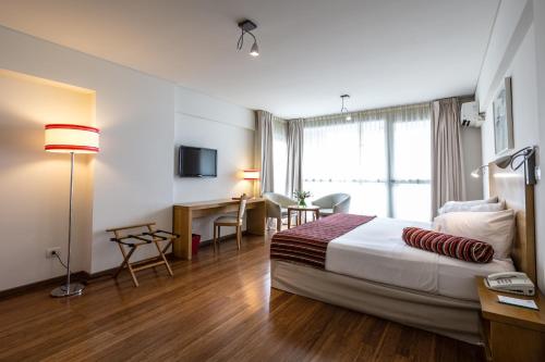 ブエノスアイレスにあるBA ソホテルのベッドとデスクが備わるホテルルームです。