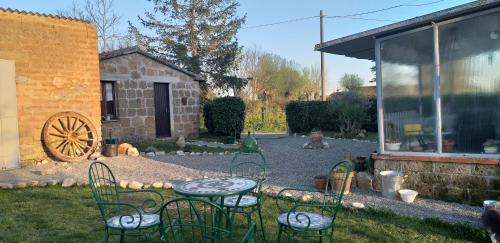 a patio with chairs and a table in a yard at La cascina della grotta di tufo in San Valentino