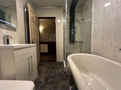 Baño blanco con bañera y lavamanos en The Nook Crieff - central 2-bed with garden :) en Crieff