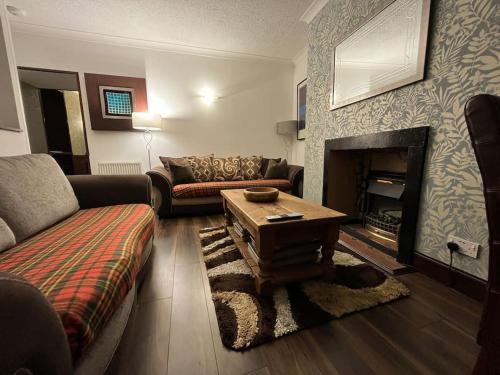 a living room with a couch and a fireplace at The Nook Crieff - central 2-bed with garden :) in Crieff