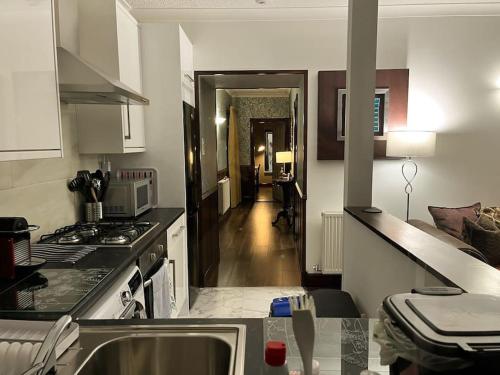 a kitchen with a sink and a stove top oven at The Nook Crieff - central 2-bed with garden :) in Crieff
