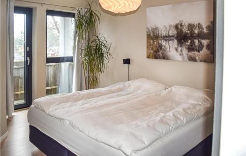 a white bed in a room with a plant at Stunning Home In Skien With Jacuzzi, Wifi And 5 Bedrooms in Skien