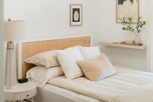 uma cama com lençóis brancos e almofadas num quarto em New! Boutique Inspired 2br Loft, Lake Geneva em Lake Geneva