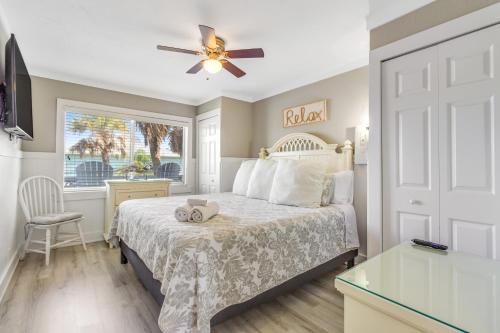 um quarto com uma cama, uma ventoinha de tecto e uma janela em Seagrass Sunsets em Bradenton Beach