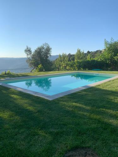 a swimming pool in the middle of a grass field at Casa da Horta - Douro Portugal in Bafueiras