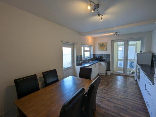 a kitchen and dining room with a wooden table and chairs at 5BR townhouse Arnos Court Villa Bristol w parking in Bristol